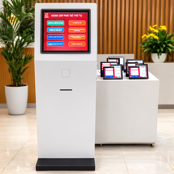 Digital kiosk with a screen displaying multiple options in an indoor setting with plants and a desk.