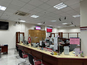 Banking counter with teller and customers in a modern bank interior.