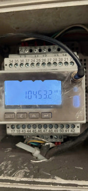 Digital display with a blue screen showing numbers on a metallic surface.
