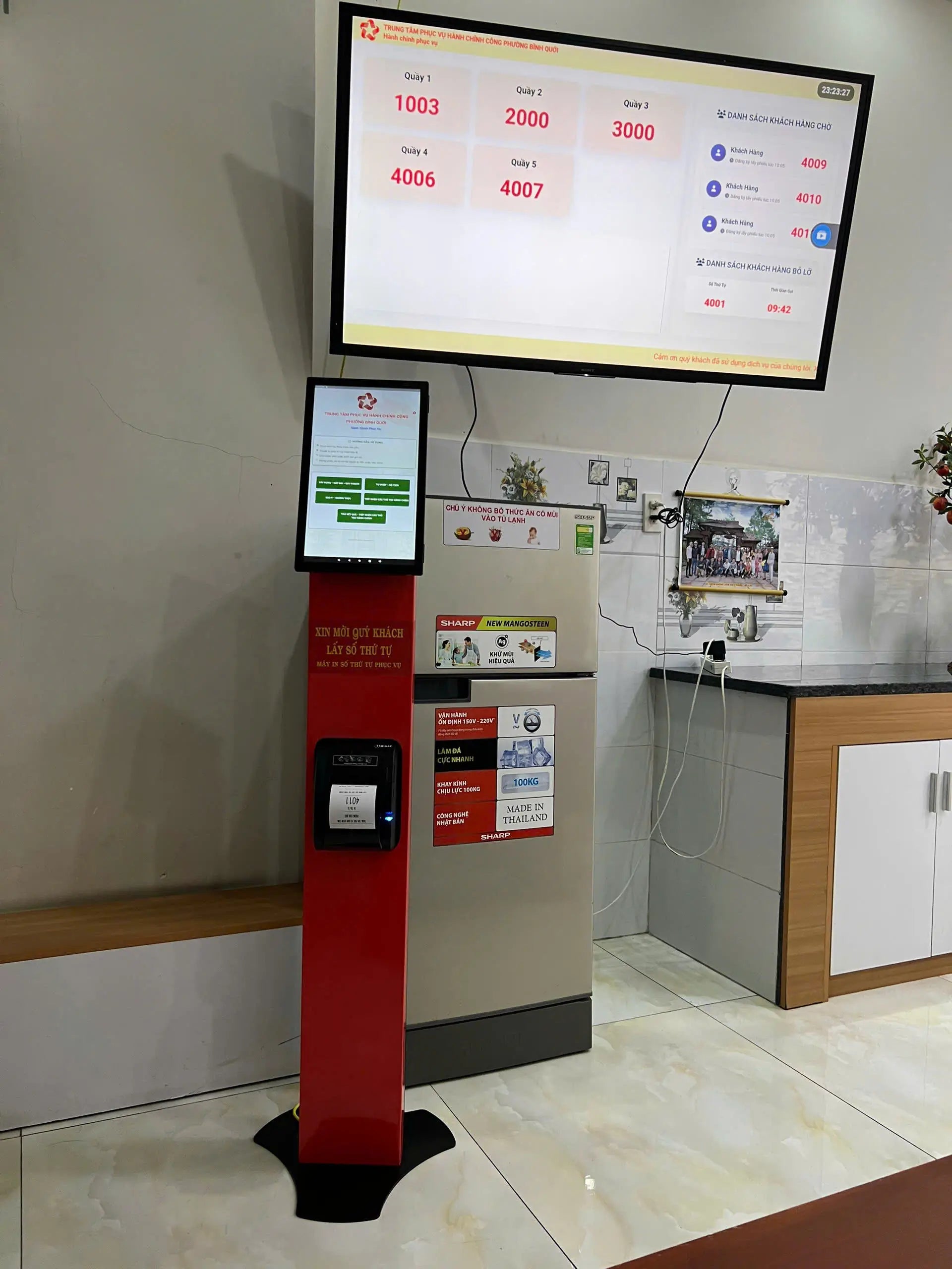 Tall red and black machine with a digital display in a room with a counter and cabinets.
