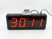 Digital clock with red LED display on a white background