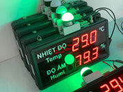 Digital temperature and humidity meter with green and red display on a white background
