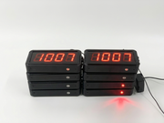 Two digital clock displays with red LED numbers on a white background