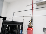 Fire extinguisher mounted on a wall next to a piece of electronic equipment.