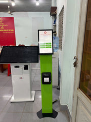 Green and white interactive kiosk with a screen in an indoor setting.