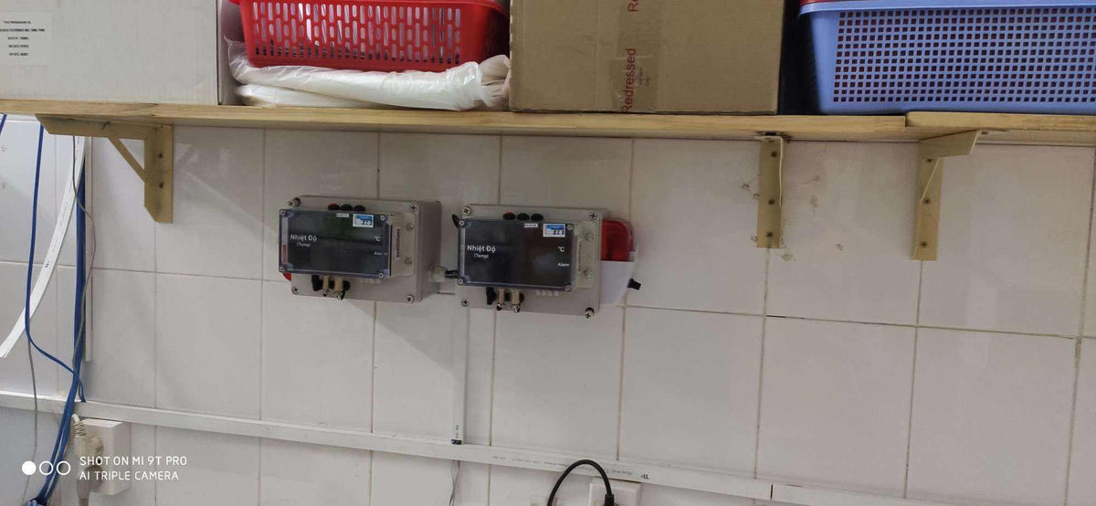 Control panels on a tiled wall with shelves above