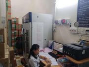 Person sitting at a desk in an office with medical equipment and supplies.