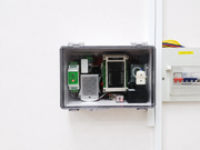 Electrical panel with various components inside a metallic box on a white background