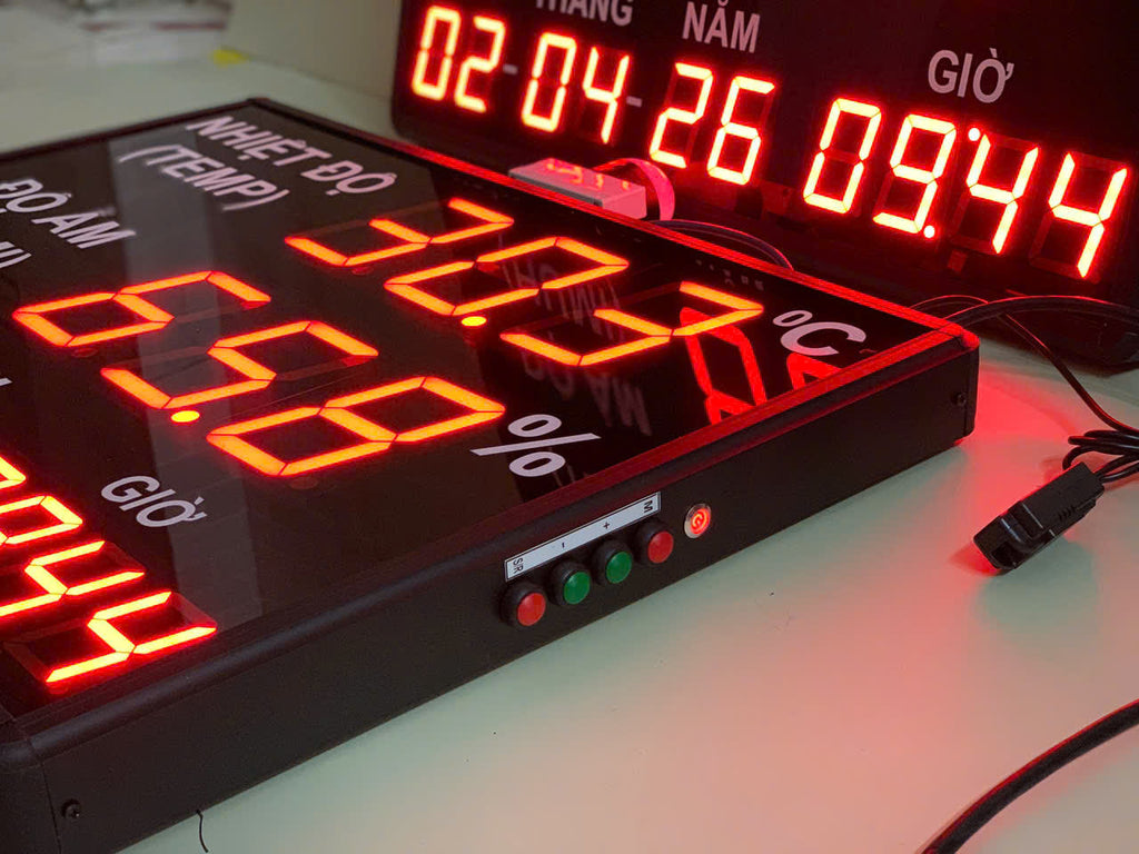 Digital clock with red LED display on a white surface