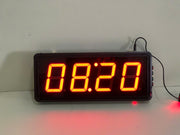 Digital clock with red LED display on a white background